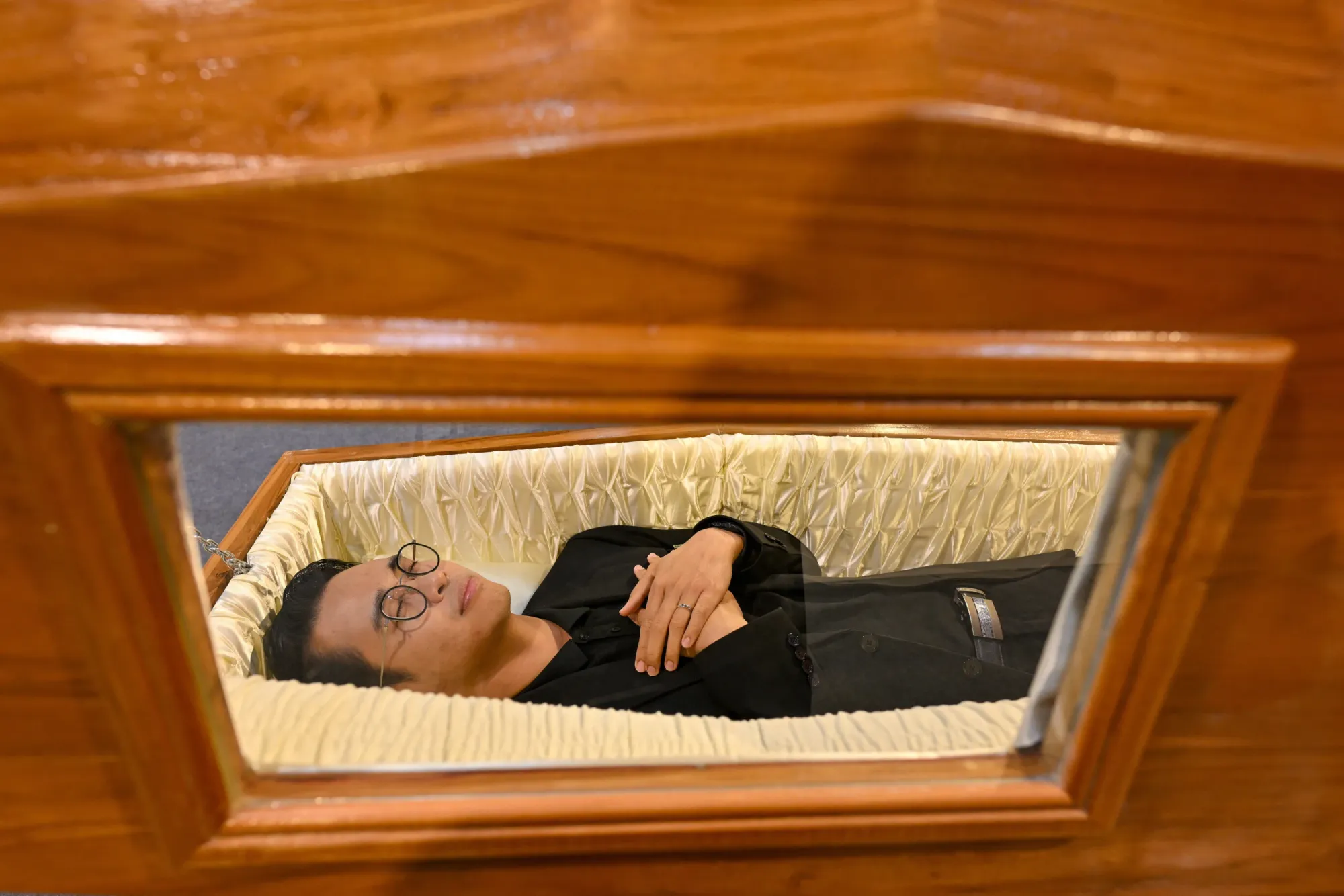 ผู้เข้าชมลองนอนในโลงศพที่งาน Death Fest จังหวัดนนทบุรี ประเทศไทย วันศุกร์ที่ 13 มีนาคม 2569 (AP Photo/กิตตินันท์ รอดสุพรรณ)