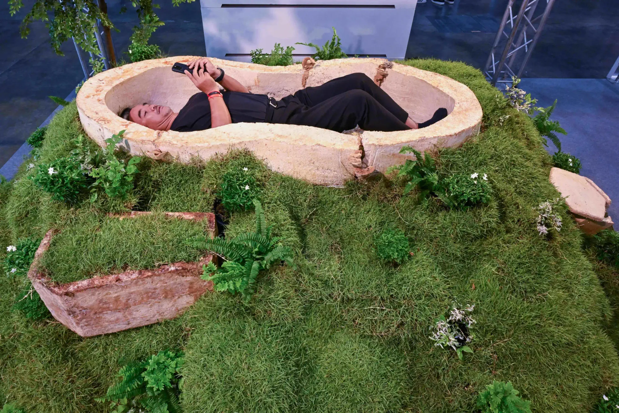 ผู้เข้าชมนอนอยู่ในโลงศพที่ทำจากไมซีเลียม หรือเส้นใยรากของเห็ดรา ที่งาน Death Fest จังหวัดนนทบุรี ประเทศไทย วันศุกร์ที่ 13 มีนาคม 2569 (AP Photo/กิตตินันท์ รอดสุพรรณ)