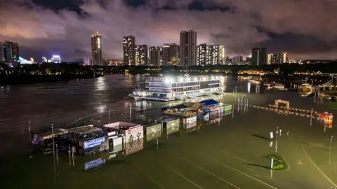 Getty Images ทางเดินริมแม่น้ำที่ถูกน้ำท่วมและร้านค้าใกล้ท่าเรือบนแม่น้ำหย่งเจียง ในหนานหนิง เขตปกครองตนเองกว่างซีทางตอนใต้ของจีน