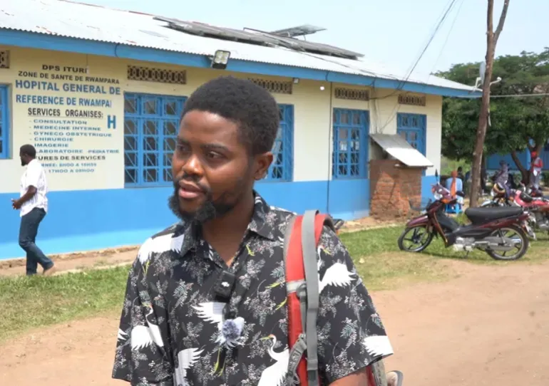 Maneba, an epidemiologist working on the DRC response team, stands outside the Rwampara General Hospital in Ituri.