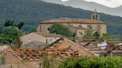 AFP via Getty Images หลังคาบ้านที่เสียหายหลังพายุทอร์นาโดถล่มหมู่บ้านโปมาส เมื่อวันที่ 24 สิงหาคม 2026