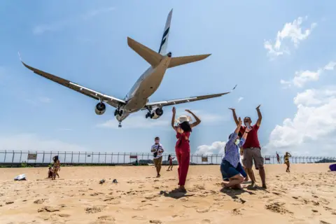 นักท่องเที่ยวเฉลิมฉลองที่หาดไม้ขาว ขณะเครื่องบินฟินน์แอร์ (Finnair) จากเฮลซิงกิลงจอดที่สนามบินนานาชาติภูเก็ต