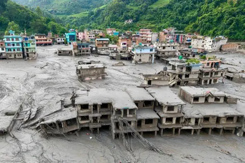 ภาพมุมสูงแสดงบ้านเรือนจมโคลนหลังน้ำท่วมฉับพลันที่เขตเดวีฆัต เทศบาลบิดูร์ จังหวัดนูวาโกฏของเนปาล เมื่อวันที่ 27 สิงหาคม 2026