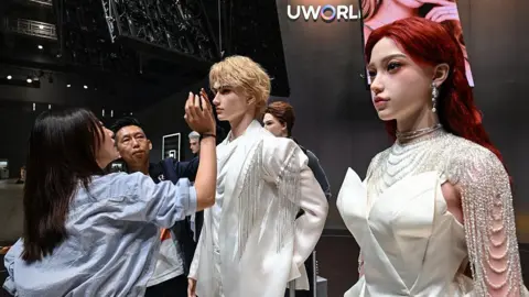 ผู้หญิงคนหนึ่งชมการจัดแสดงหุ่นยนต์ฮิวแมนนอยด์เหมือนจริงของ UBTech