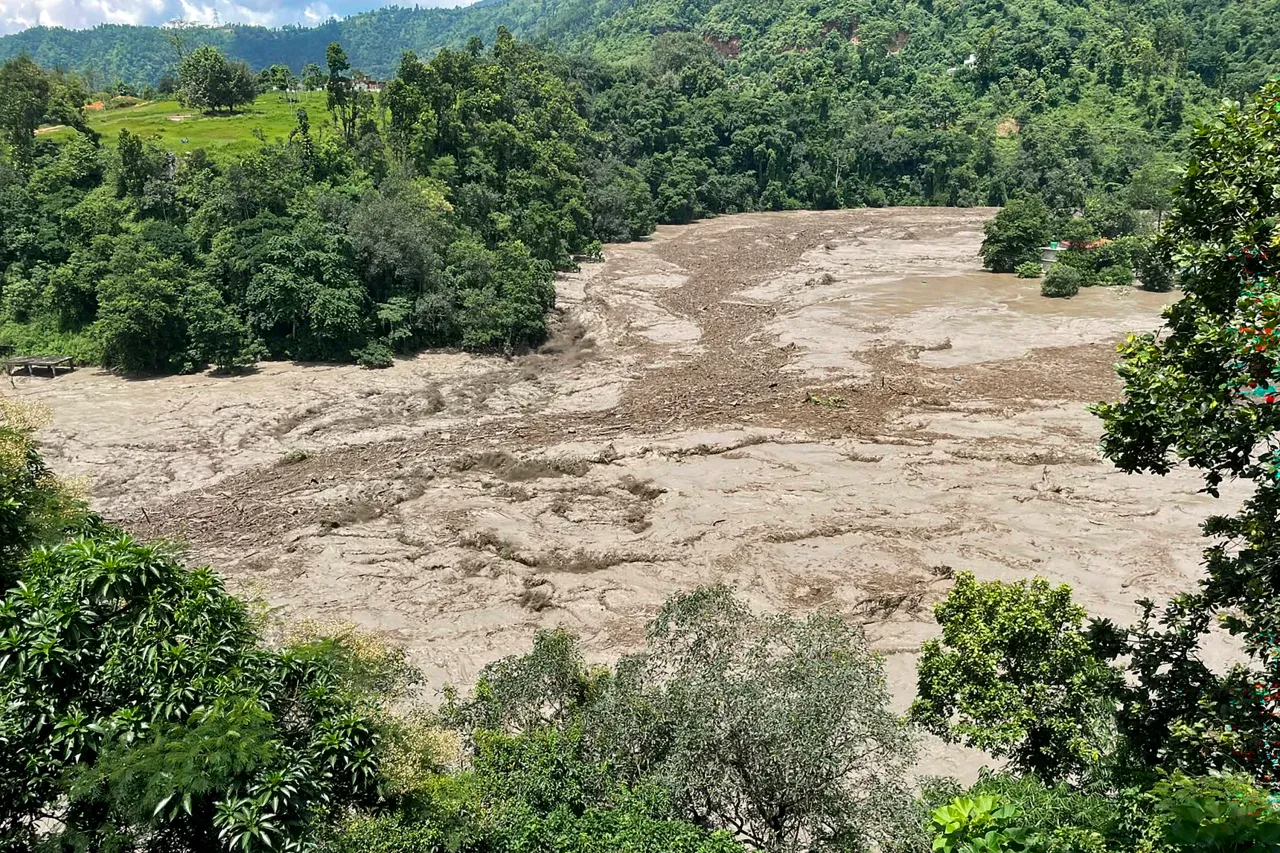 A torrent of muddy water surges through a river after flash floods at Galchhi in Nepal's Dhading district