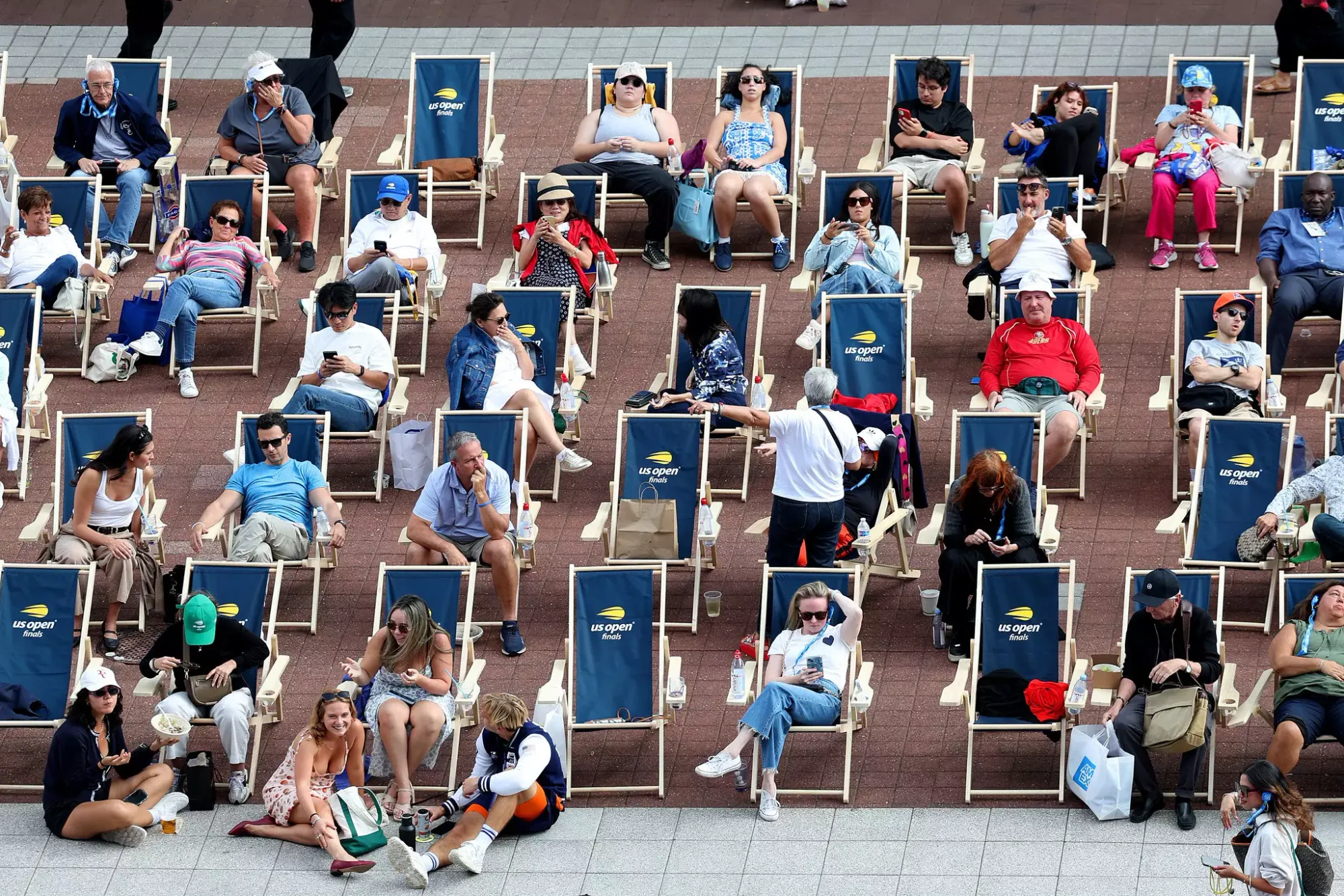 Tennis fans sitting in lines of deckchairs with a