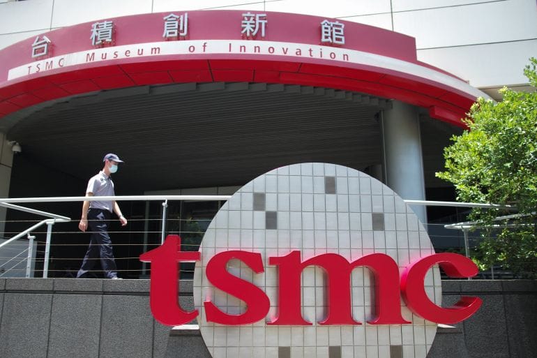 พนักงานรักษาความปลอดภัยเดินผ่านโลโก้ TSMC ที่อุทยานวิทยาศาสตร์ซินจู๋ เมืองซินจู๋ ไต้หวัน