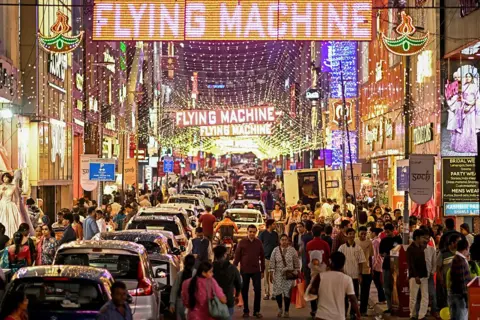 ผู้คนจับจ่ายที่ถนน Commercial Street ที่ประดับไฟสว่างไสวในคืนก่อนวันดิวาลี เทศกาลแห่งแสงไฟของชาวฮินดู ที่เบงกาลูรู เมื่อวันที่ 19 ตุลาคม 2025