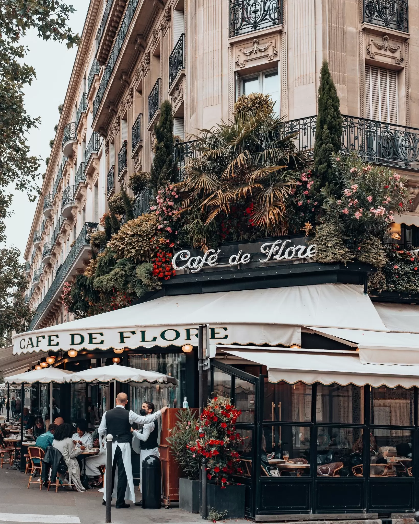 ลูกค้าและพนักงานเสิร์ฟหน้าร้าน Café de Flore ในย่านแซงต์-แชร์แมงของปารีส