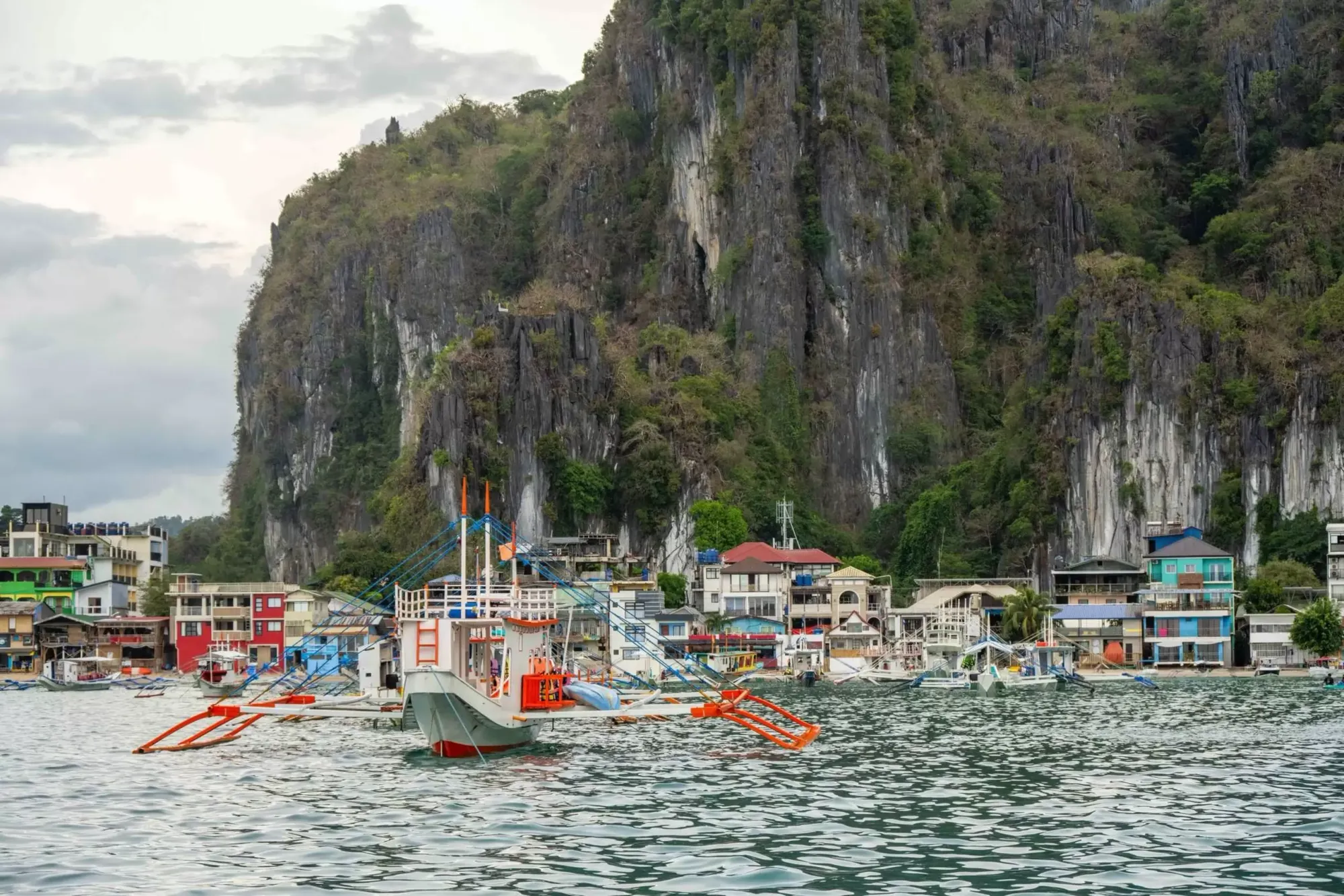 บ้านแคบๆ ริมทะเลที่มีหน้าผาอยู่ด้านหลัง ในเอลนีโด ฟิลิปปินส์